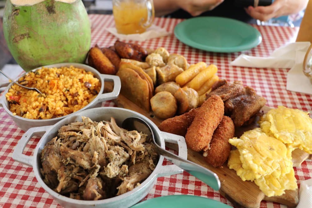 a sampler plate of delicious puerto rican food including fried snacks and pulled pork and rice