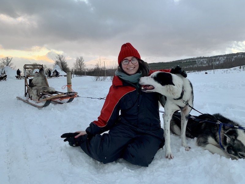 Allison posing with a friendly husky after a dog sledding tour in Tromso