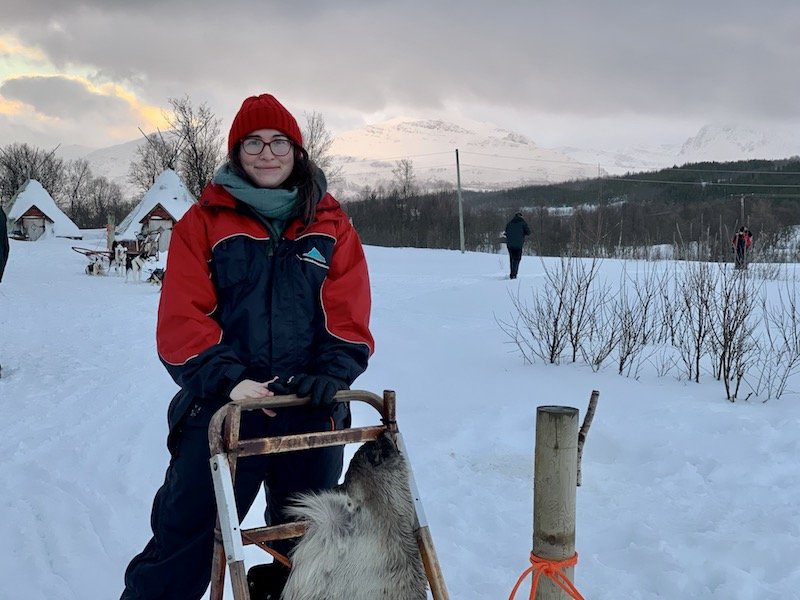 Allison smiling at the helm of a sledge for driving sled dogs