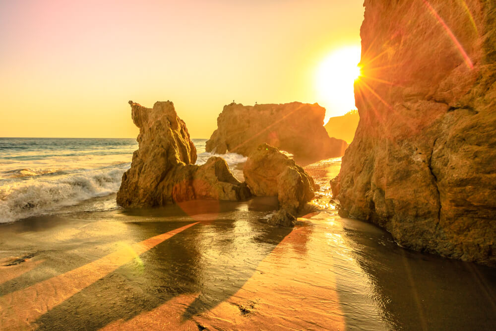 Sunset falling over the Pacific at El Matador Beach in Malibu bathing the water and beach in a beautiful orange glow at sunset, finishing the perfect day in Malibu