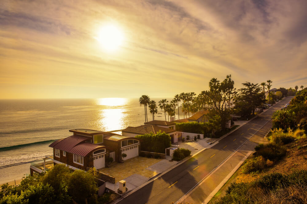 Sun setting over the coastline of Malibu with the pacific coast highway and beach being bathed in golden light on a Malibu day trip.