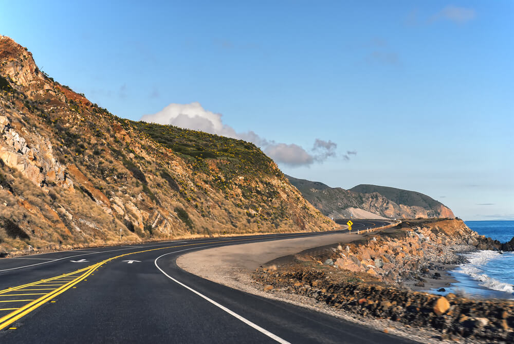 view of the pacific coast highway winding through malibu, driving to malibu for a day trip from LA