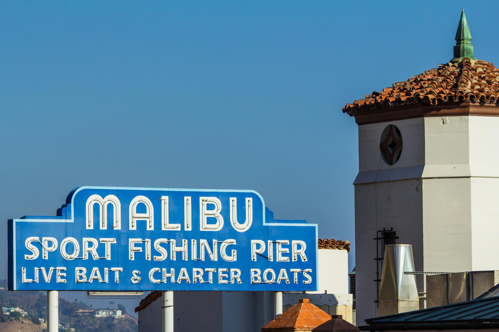 Iconic sign marking the Malibu Pier, along the Pacific Coast Highway in southern California. "Malibu sport fishing pier, live bait & charter boats".