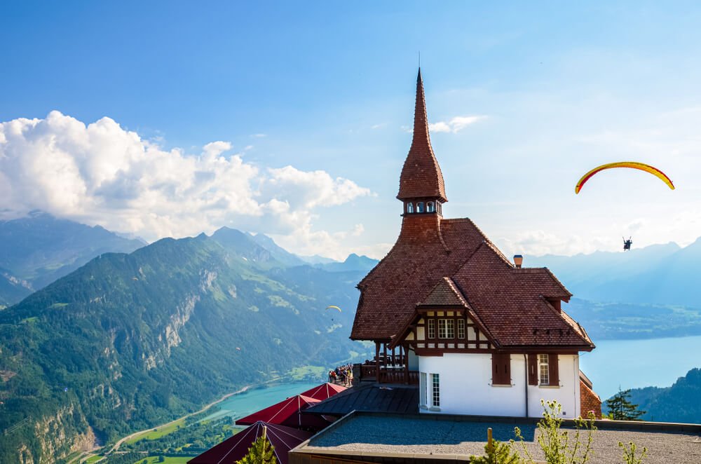 Stunning view of the top of Harder Kulm in Interlaken, Switzerland photographed in summer with paragliders flying around. 