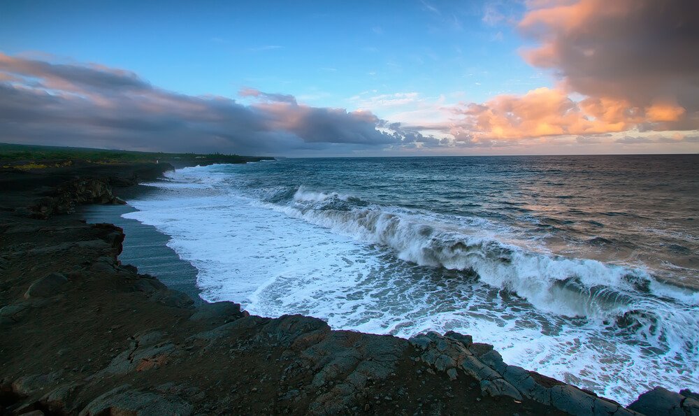 Views of the sea and black lava rocks of recent eruptions of Kilauea from Kalapana for sunset, Puna district, Big island, Hawaii