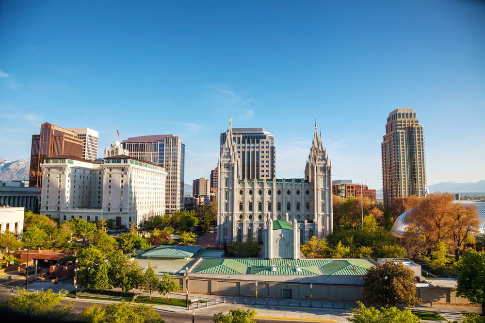 The skyline of Salt Lake City in the afternoon light with autumn trees and green trees