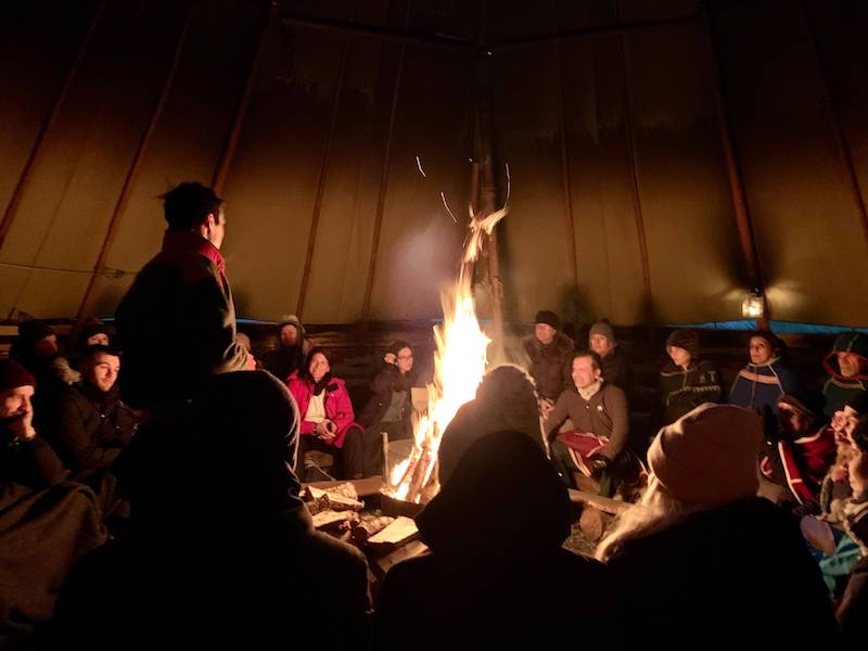 Sami guide telling tourists about Sami culture in the lavvu, the traditional Sami tent