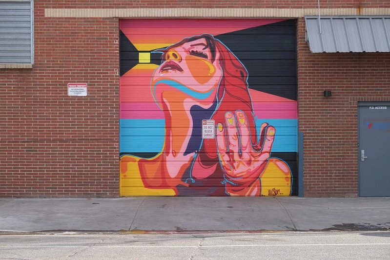 Mural of a woman looking up to the sky, pop art style, in Denver Colorado