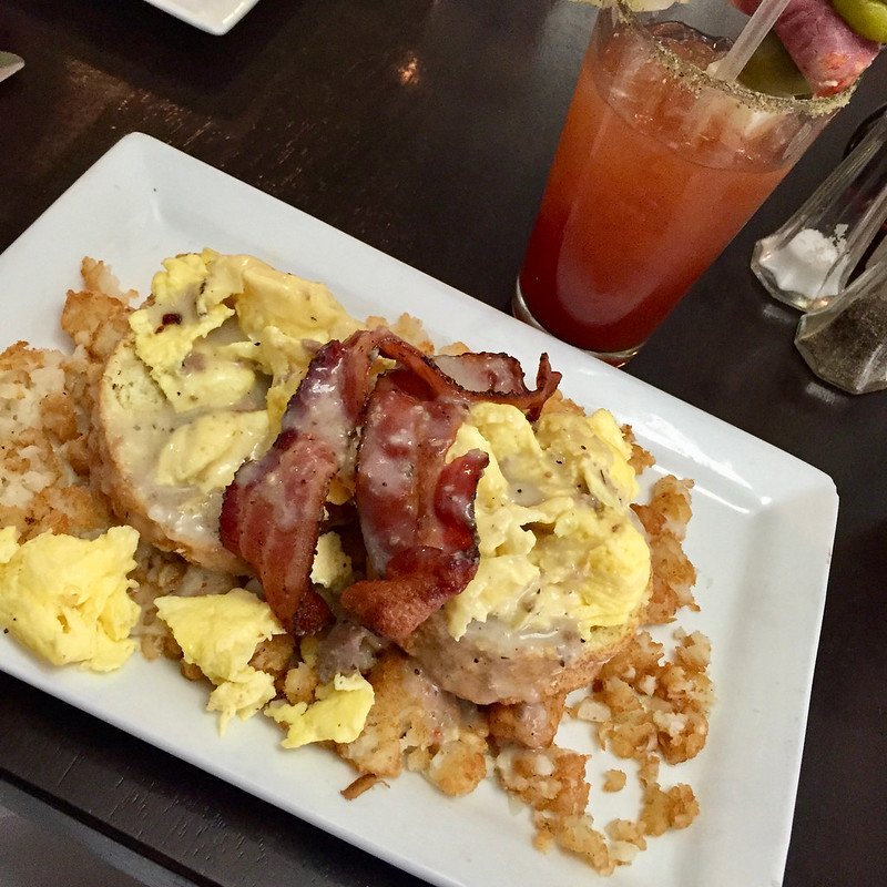 Biscuits, eggs, hash brows, gravy, and bacon with a bloody mary