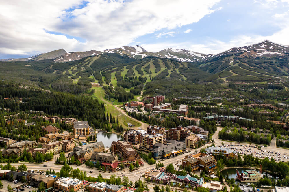 the city of breckenridge in the summer, surrounded by mountains and houses