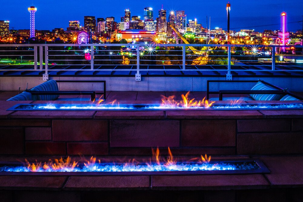 colorful view of denver at night with lit up fire pits and city colors