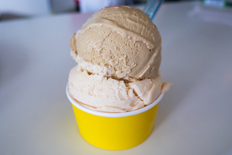 Scoop of Kona coffe and macadamia nut ice cream in a yellow cup