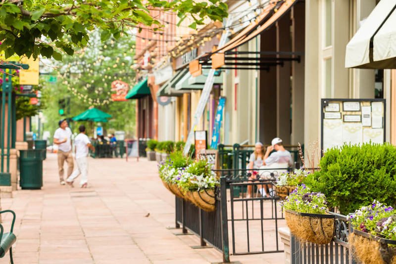 The historic downtown area of Denver with summer plants and people out enjoying restaurant seating outdoors