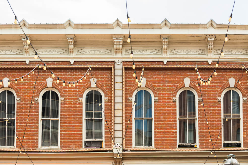 Windows of the historical brick building on Larimer Square with string lights in front of it