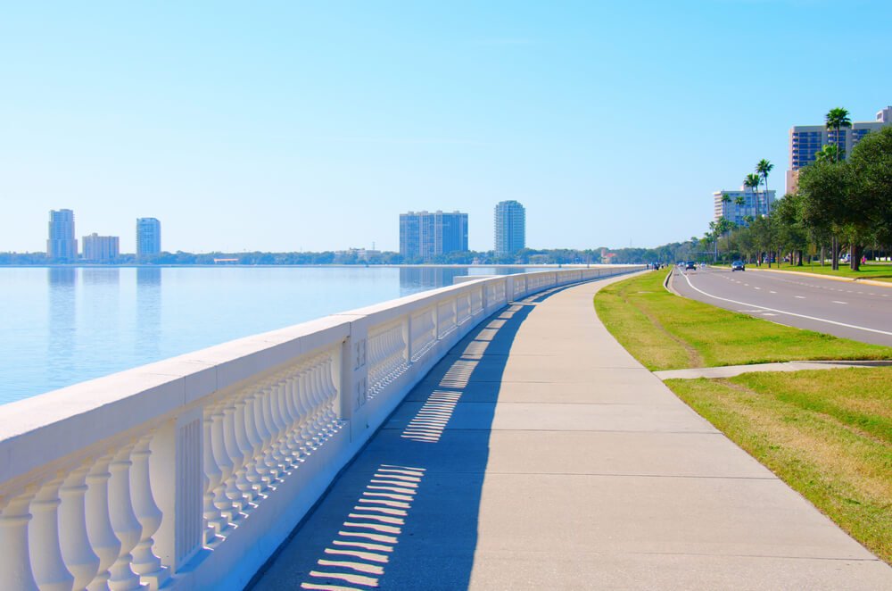 long sidewalk curved along the bay of tampa with skyscrapers in the distance