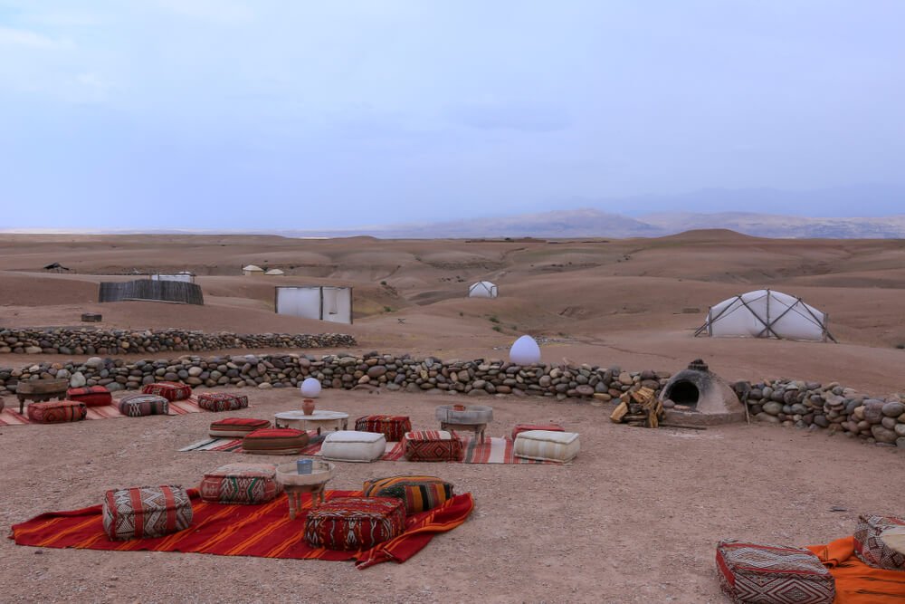 Cushions set up around tables to enjoy tea in the rock desert outside of Marrakech