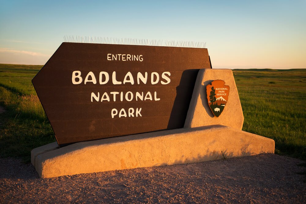 NPS Sign reading "Entering Badlands National Park" in the late afternoon sunset light