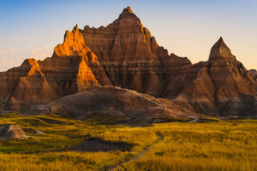 One of the many pointed rock formations of Badlands National Park with sunset light making shadows