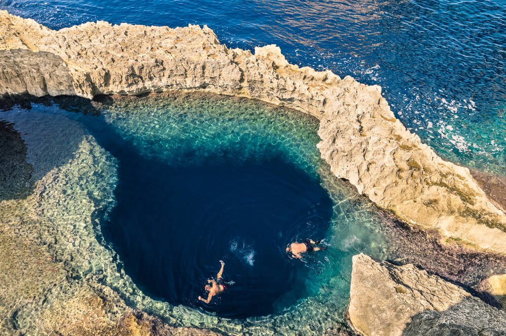 People jumping into the Blue Hole in Gozo