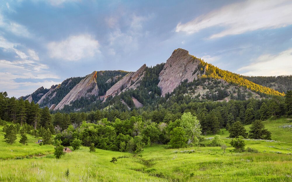 The distinctive rock formations of the Flatirons which look like three irons in a row surrounded by trees