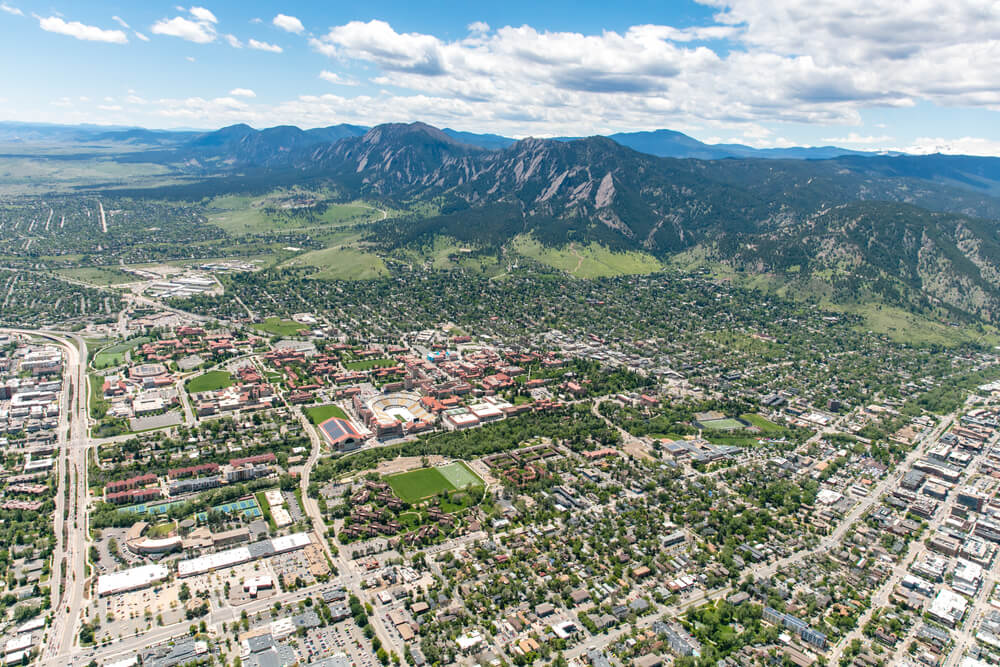 An aerial photo of Boulder Colorado with mountain and hills in the distance