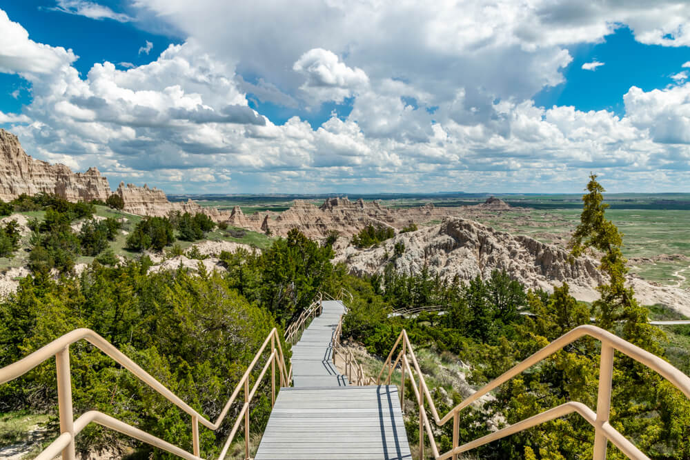 Stair trail boardwalk leading to beautiful rock formations amidst a green lush landscape in the Badlands