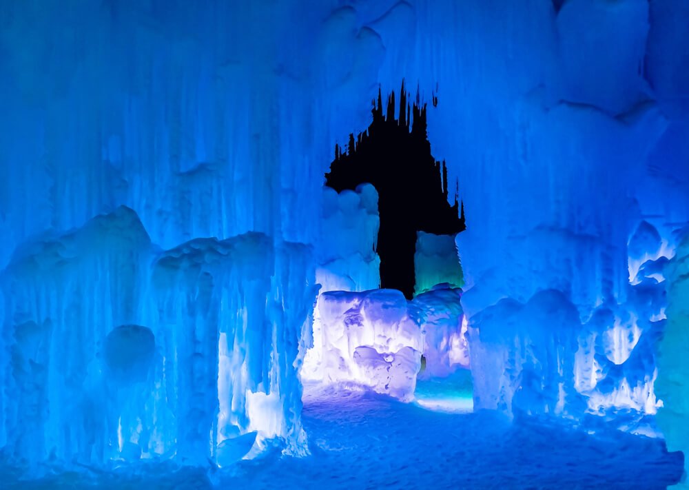 Ice Castles lit up at night with blue light and icicles