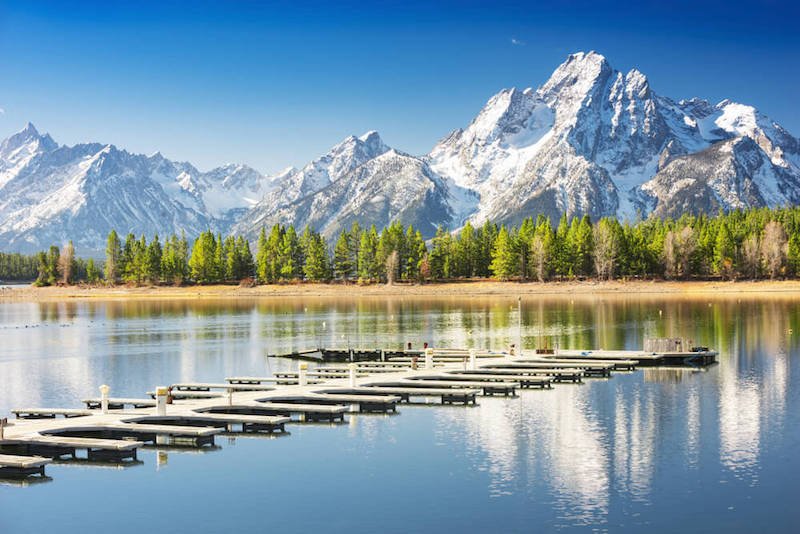 view of a marina with all the boats out on the lake with lots of mountains in the distance