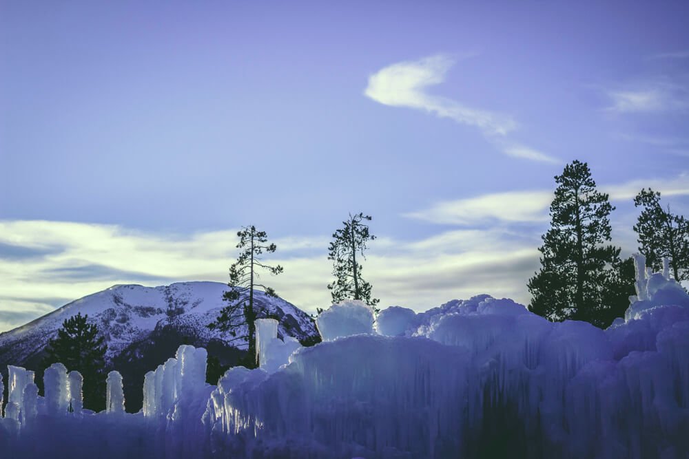 Area around the Ice Castles in Dillon with trees and mountains behind the castle formation