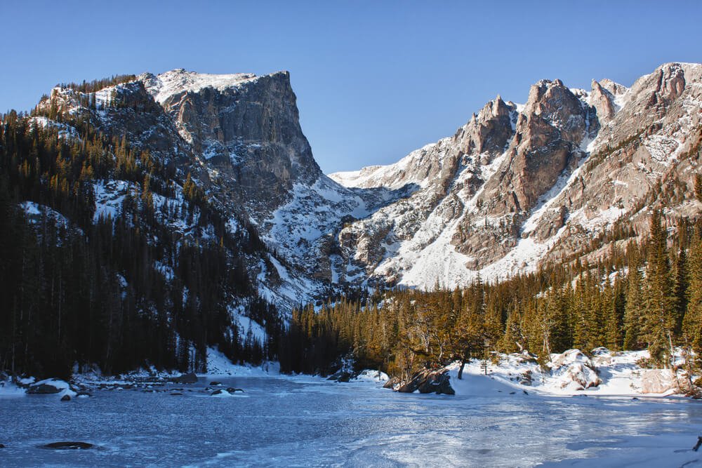 Emerald lake in rocky mountains national park, CO in winter with frozen ice sheet on the lake and snow