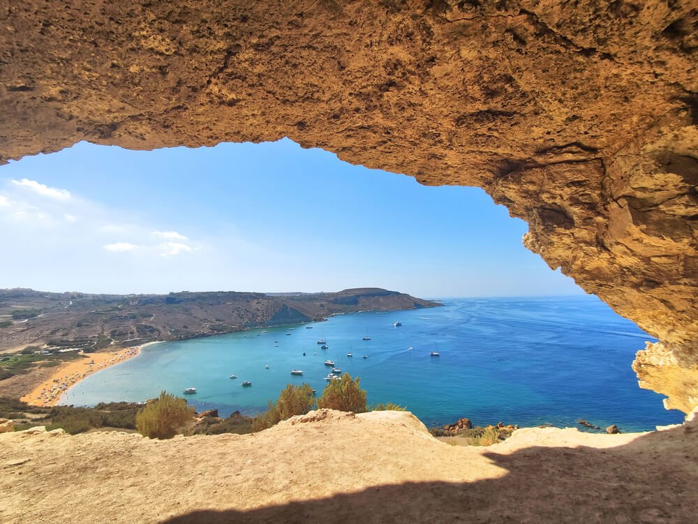 Photo of the waters of ramla bay and ramla beach as seen from a cave above the water