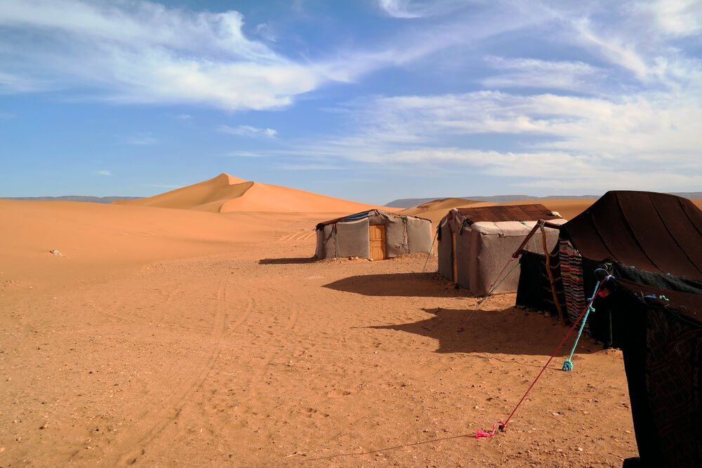 Desert camp at Tinfou sand dunes, Zagora, Morocco on a sunny day, with some rudimentary tents
