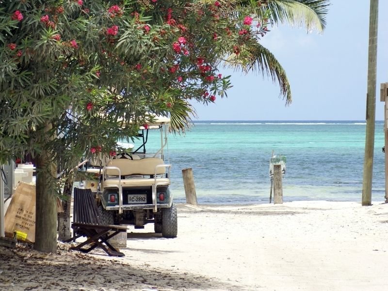 A golf cart on the sand on a beach in Belize on San Pedro
