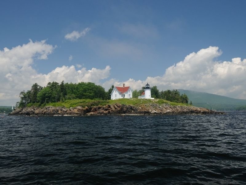 the lighthouse on curtis island as seen from the rough choppy waters out on the bay near camden maine
