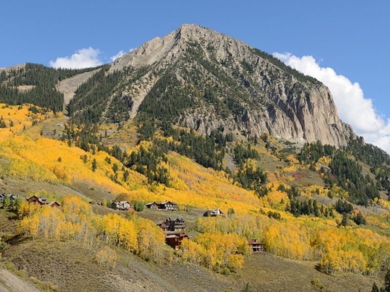 yellow aspens among small cute wood cabins in crested butte colorado in fall colors