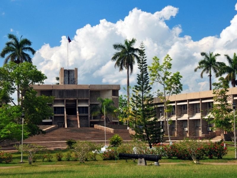 parliament building in belmopan belize with trees and flowers and steps