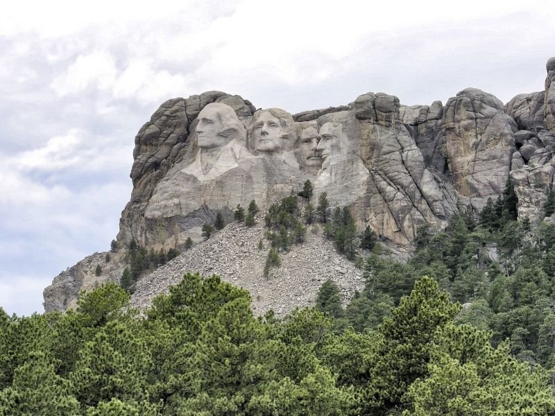 A further away view of the four faces of Mt Rushmore so that you can see the scale of the sculpture against mountain and trees