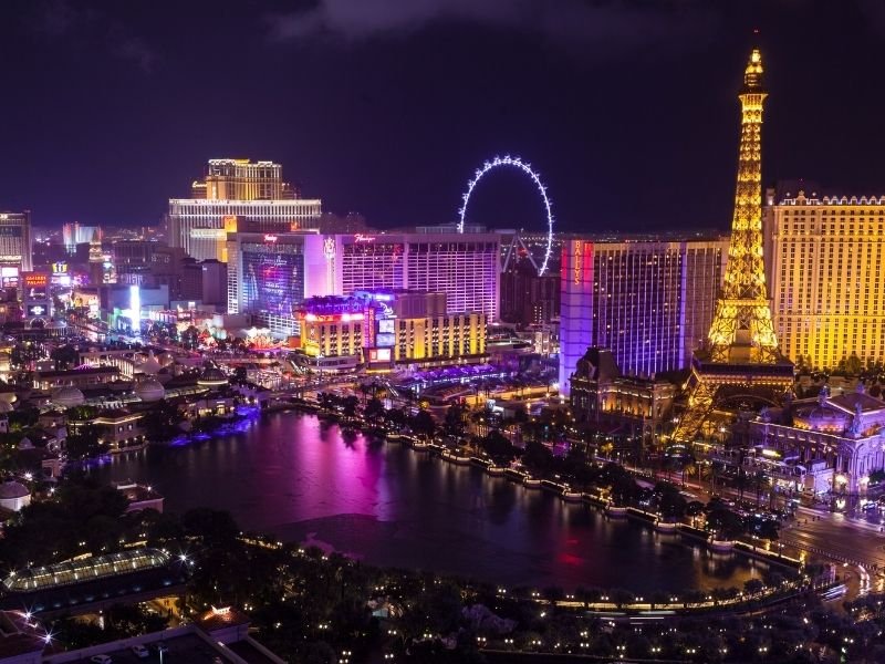 the las vegas strip lit up at night in colors of gold purple and more