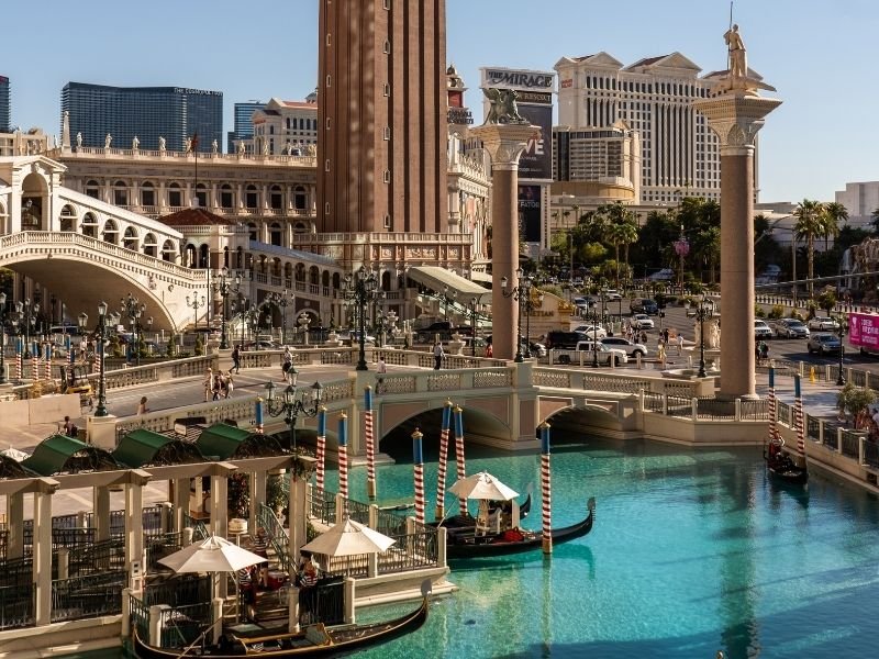 realistic venetian-style architecture with gondolas, a pool, a bridge and a replica tower