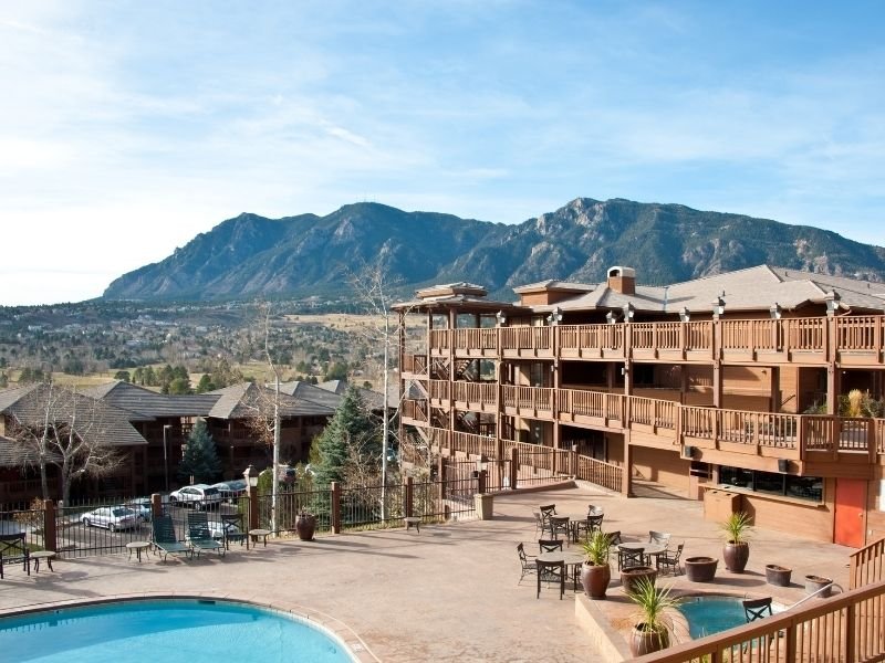 mountain lodge resort with pools and a mountain in the distance near colorado springs co