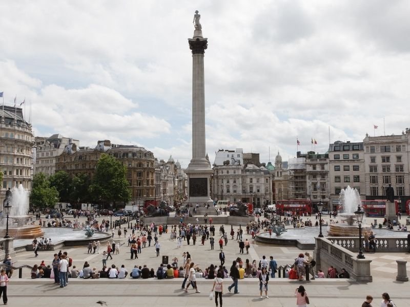 many people gathering in front of trafalgar square, a vibrant area in lodon