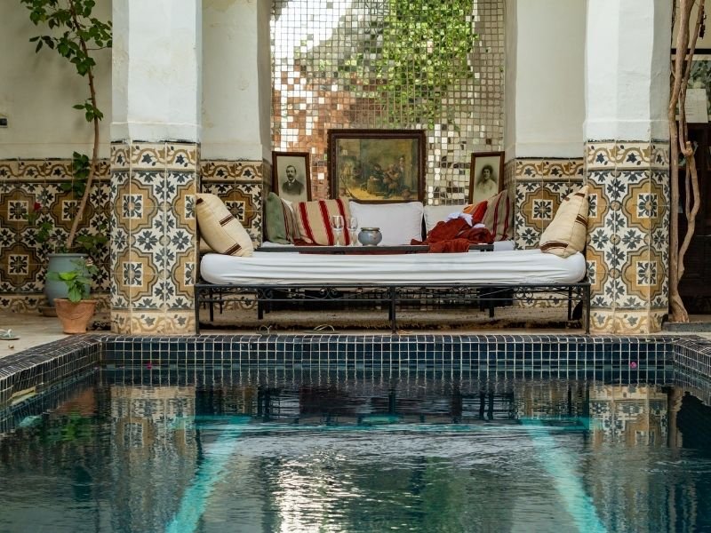 pool in a marrakech riad courtyard with a pretty sofa