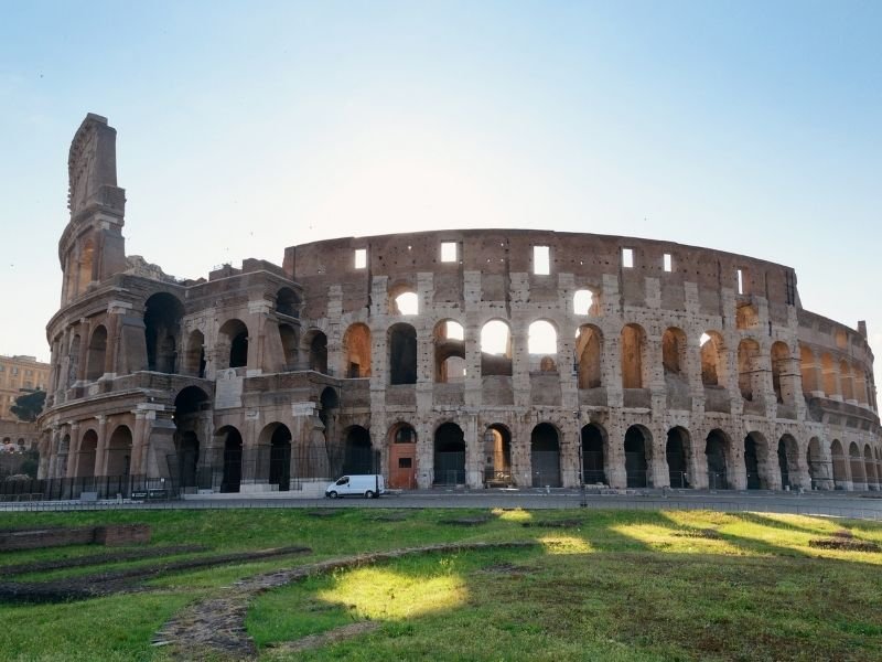 The Colosseum in Rome as seen on a day where the sun is shining through the windows from the side