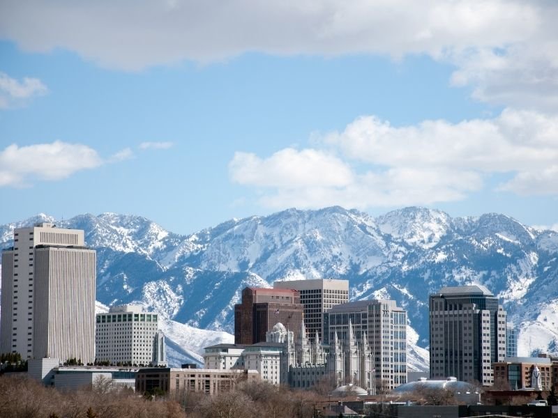 snowy mountains behind skyline of salt lake city including the notable mormon temple building