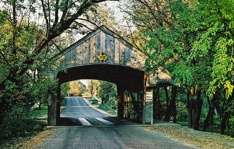 a stylized photo of the covered bridge in long grove illinois in the summer with green trees