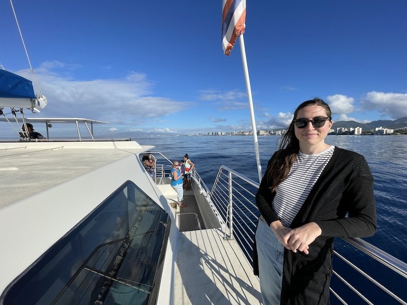 Allison wearing a striped shirt and cardigan on a boat