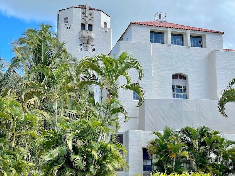 palms and other plant life in front of the white architecture of honolulu city hall