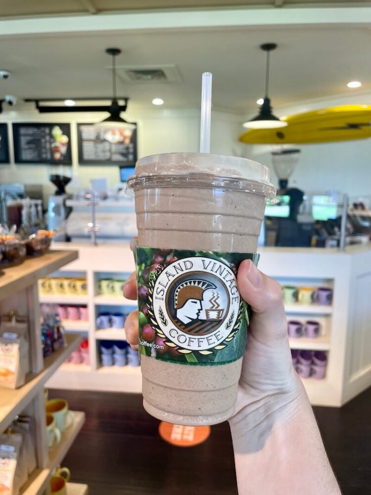 hand holding a frozen coffee drink in a coffee shop