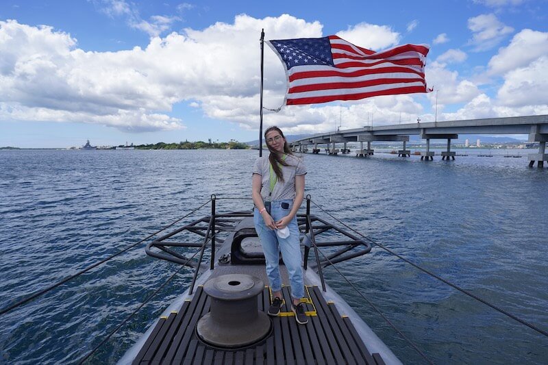 standing at pearl harbor with an american flag in the background