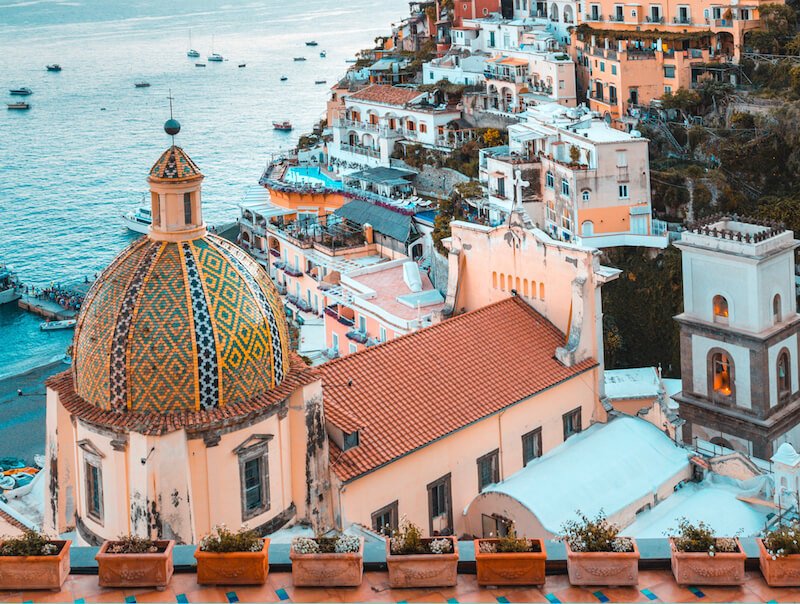 detail of the amalfi coast town of positano with mosaic roof and beach and hillside houses